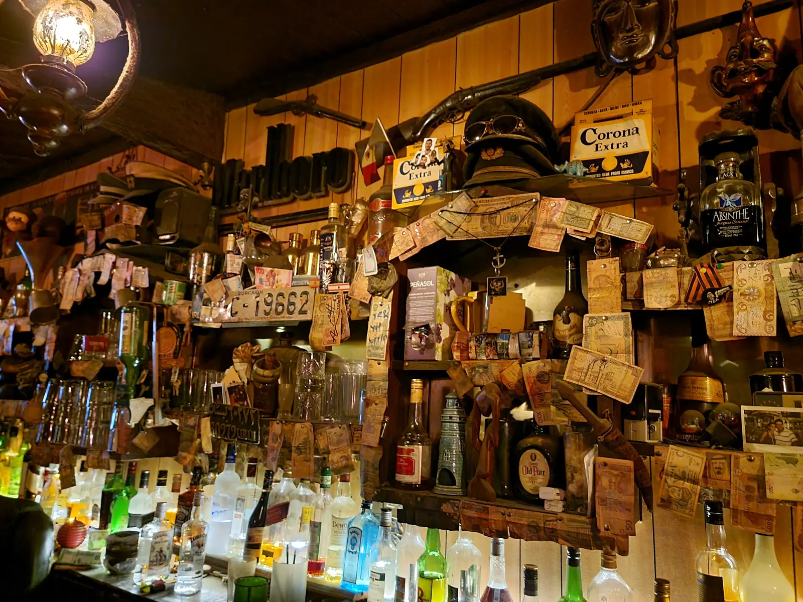 The back bar at Captain's Cabin, shelves crowded with bottles and souvenirs under warm light