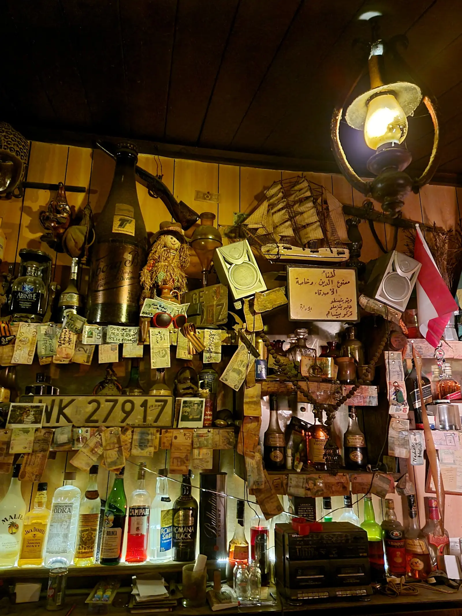 Flags from many countries hanging above a shelf crowded with notes, business cards and mementoes left by visitors